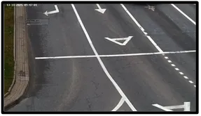 LPR camera view of an empty road lane with a turn-arrow marking, angled to capture approaching vehicles