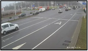 TL camera view of a person and vehicles near the stop line with a visible traffic light signal at the intersection approach