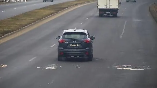 Good camera mount example: elevated rear view of an SUV in a highway lane with the plate clearly legible