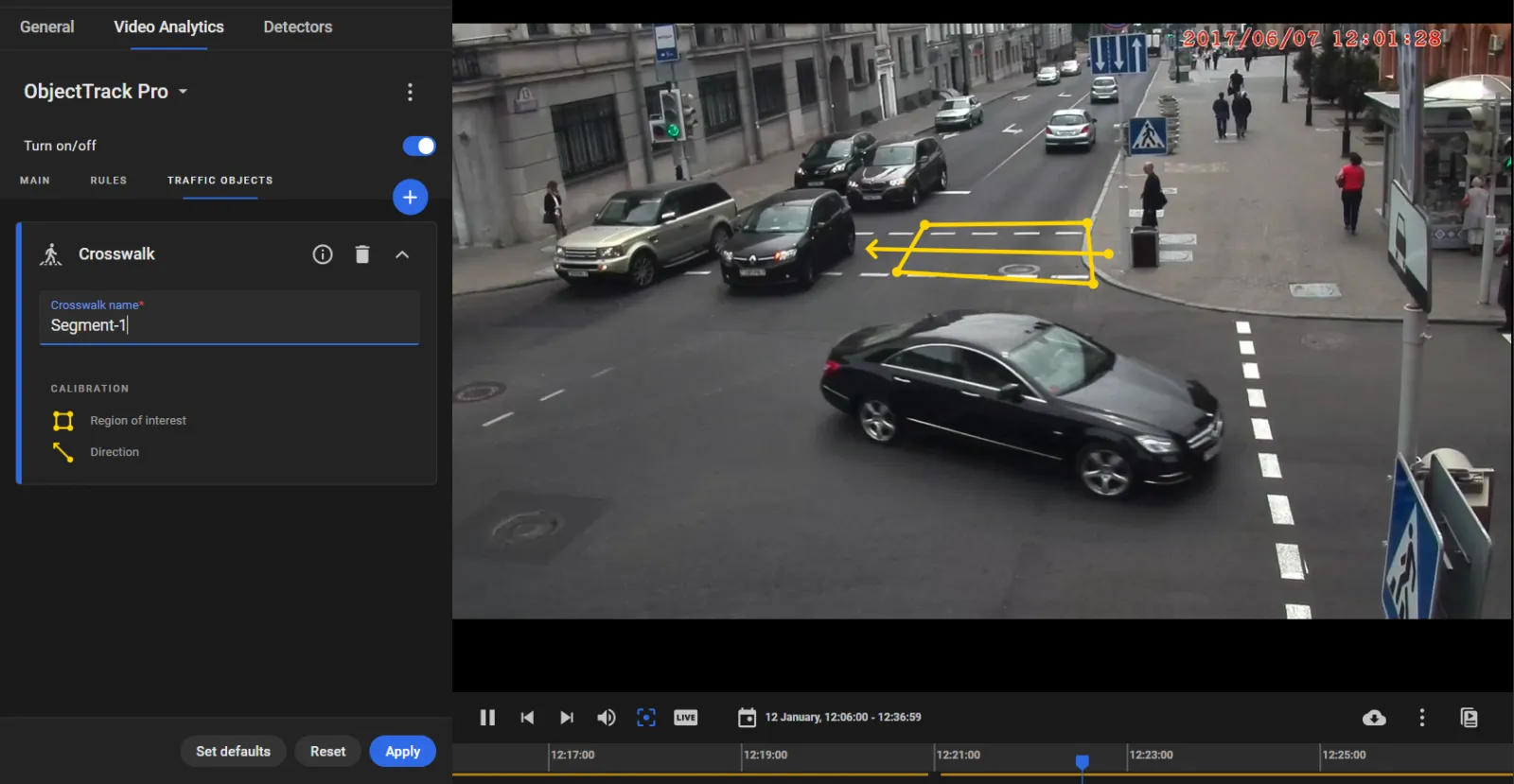 Crosswalk card named Segment-1 on the Traffic objects tab, over a street intersection camera feed with the crosswalk region and direction arrow drawn in yellow
