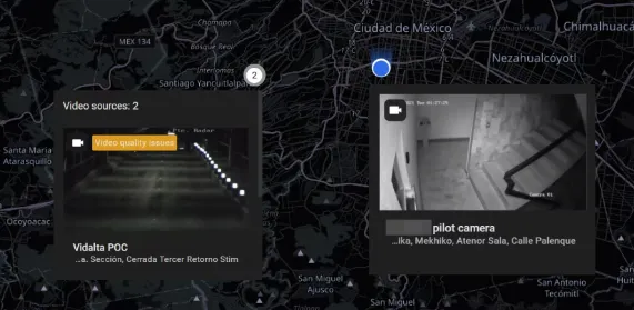 World map with two camera clusters expanded, showing preview thumbnails and location details for a video source with a quality issue and a pilot camera